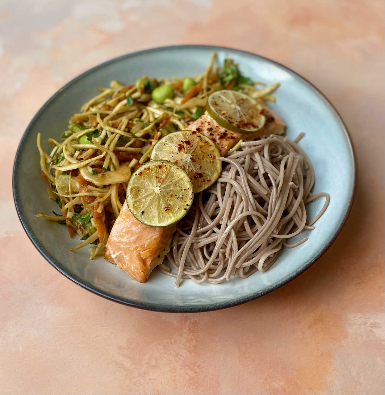 Lime & Chilli Baked Salmon with Crunchy Edamame Bean Salad - A vibrant, nourishing bowl combining baked salmon, nutty soba noodles, crunchy vegetables, and pops of edamame — all tossed in a zingy Asian-inspired dressing.
